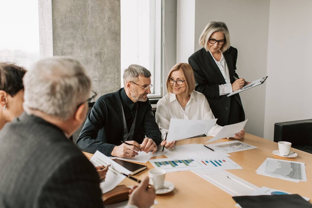 a group of people working together in a meeting room to design strategic Fractional CFO Services